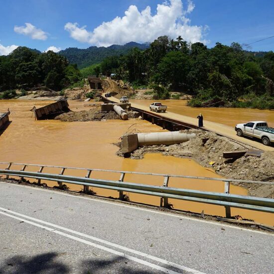 A car is driving down the road in the mud.