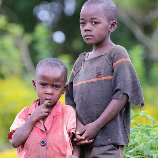 Two young boys standing next to each other.