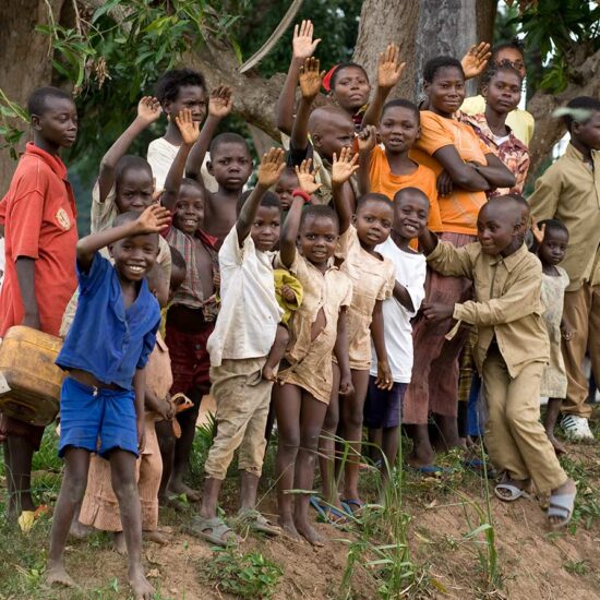 A group of children standing in the dirt.