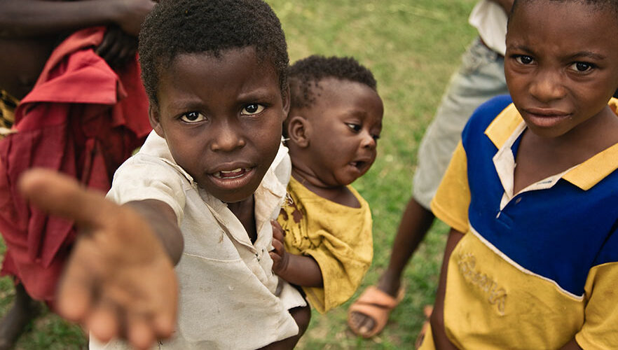 A group of children standing in the grass.