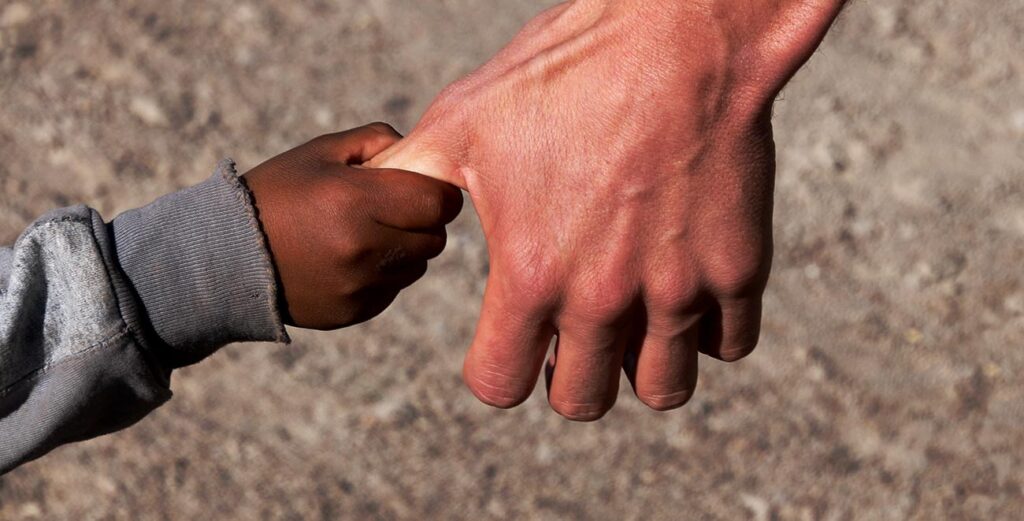 A person holding another persons hand with one of them touching it.