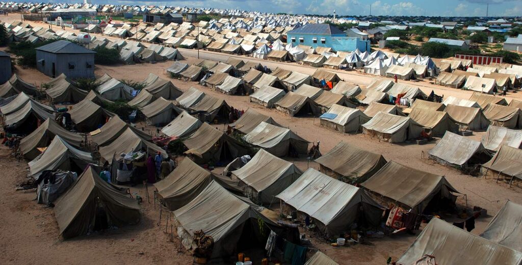A large group of tents in the sand.
