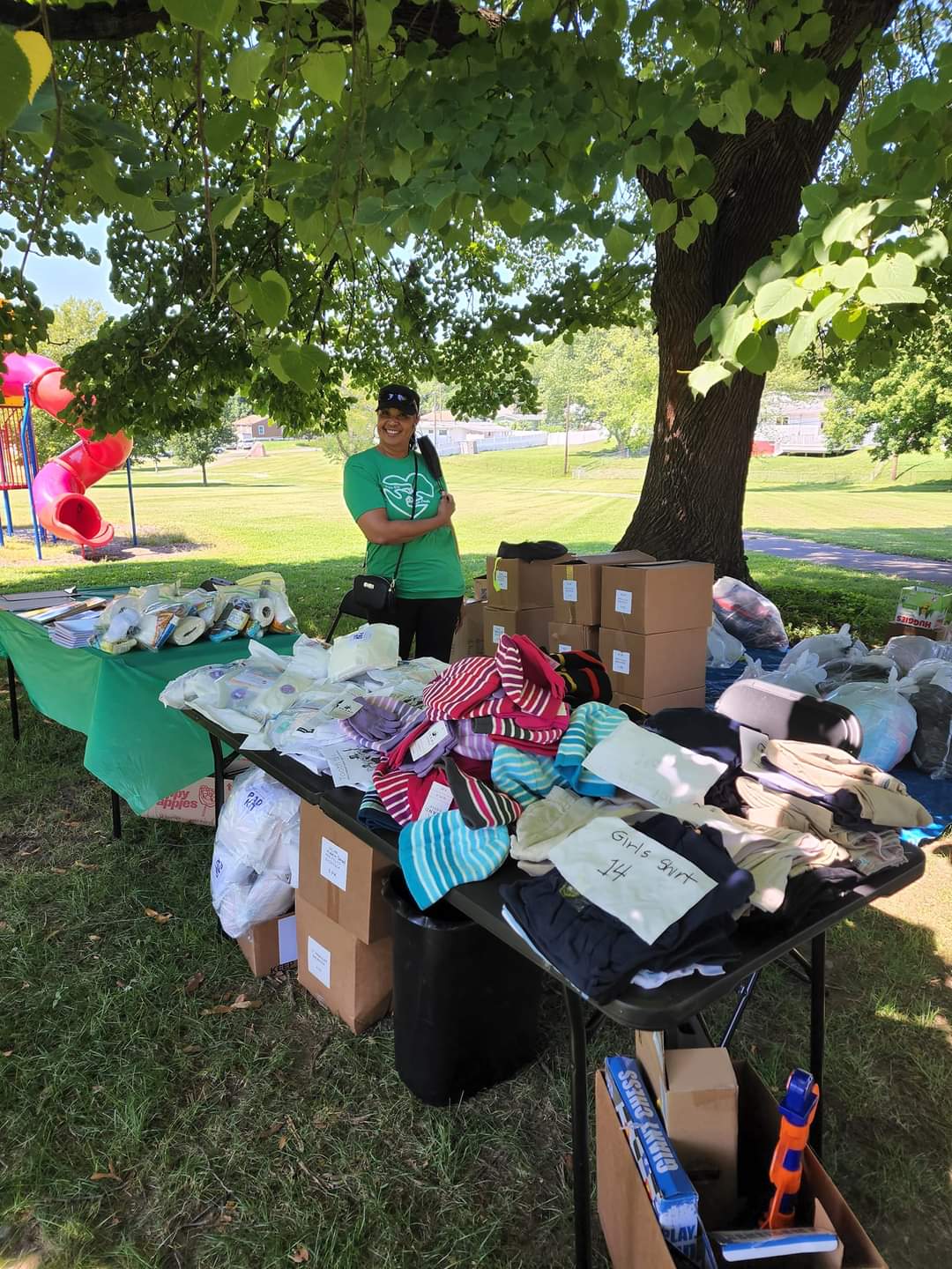 A table with many items on it and a person standing next to the table