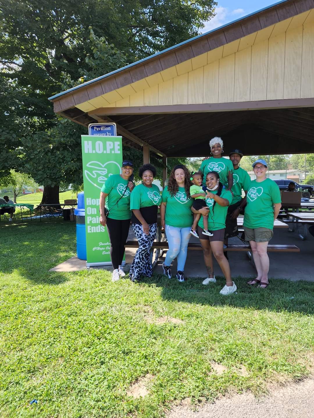 A group of people standing under a shelter.