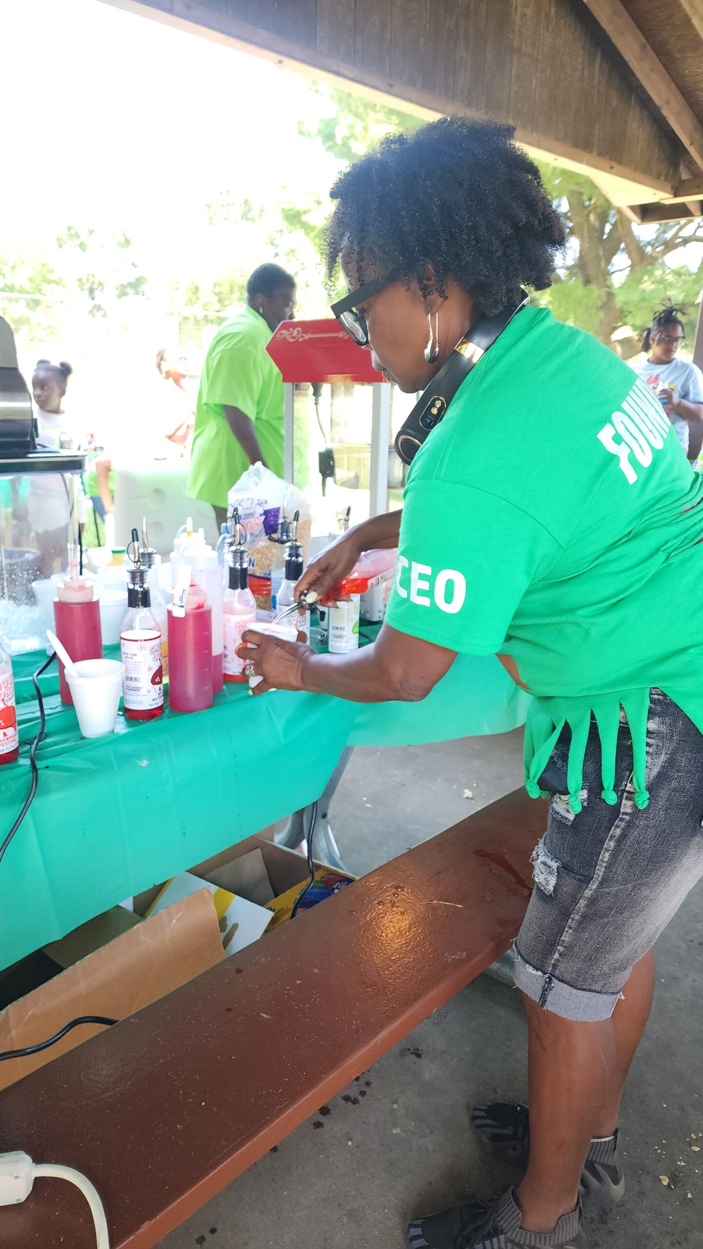 A woman in green shirt setting up drinks.