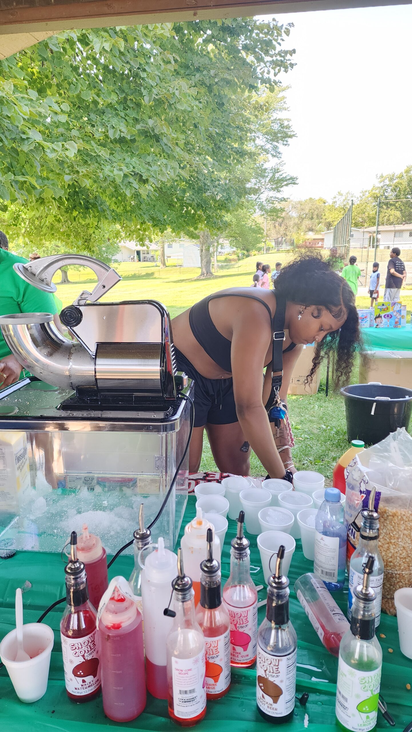 A woman standing next to a table with drinks on it.