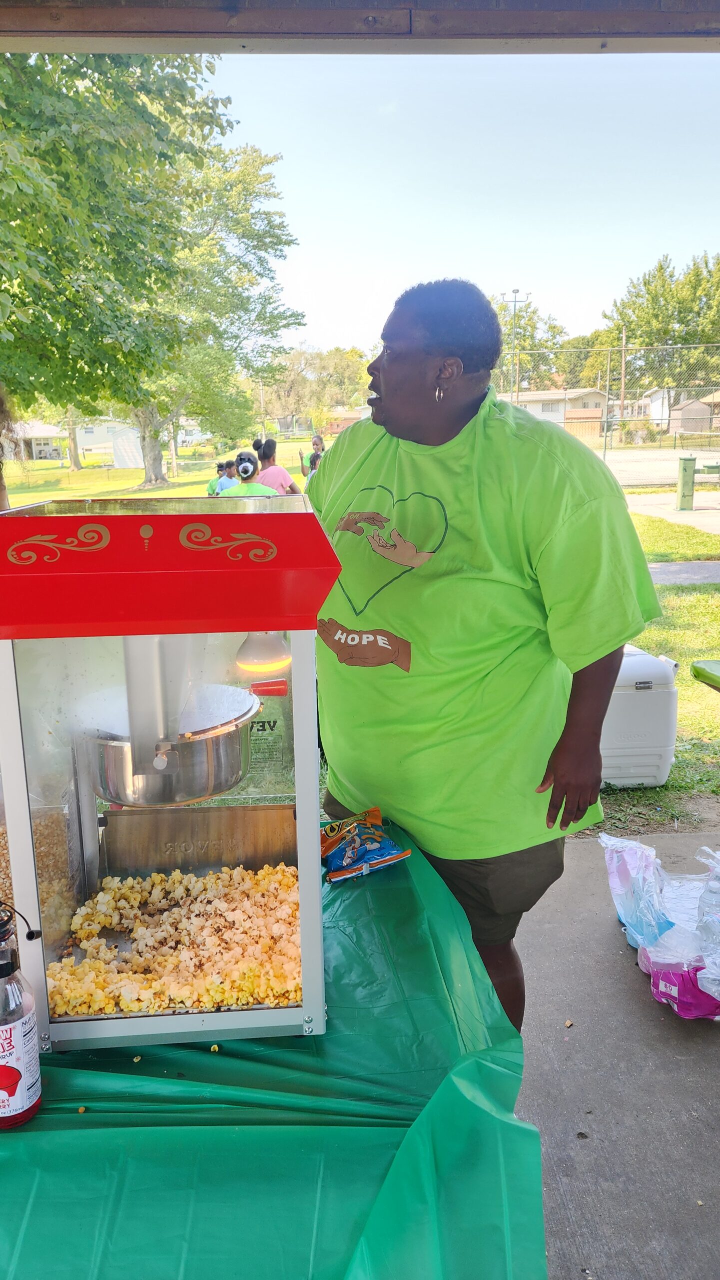 A man standing next to a popcorn machine.