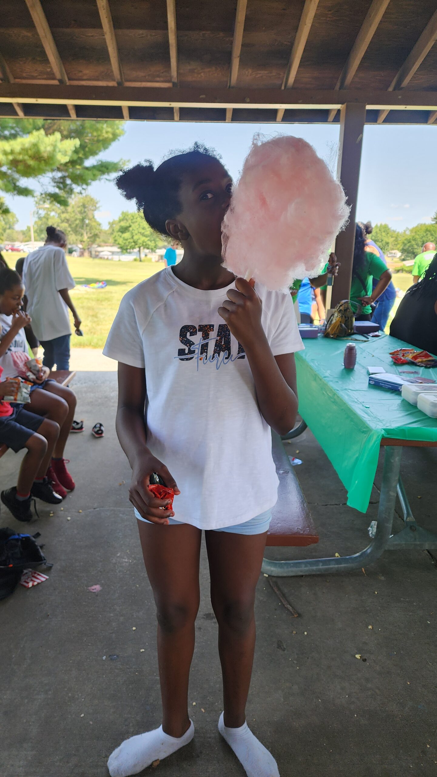 A girl holding a cotton candy in her hand.