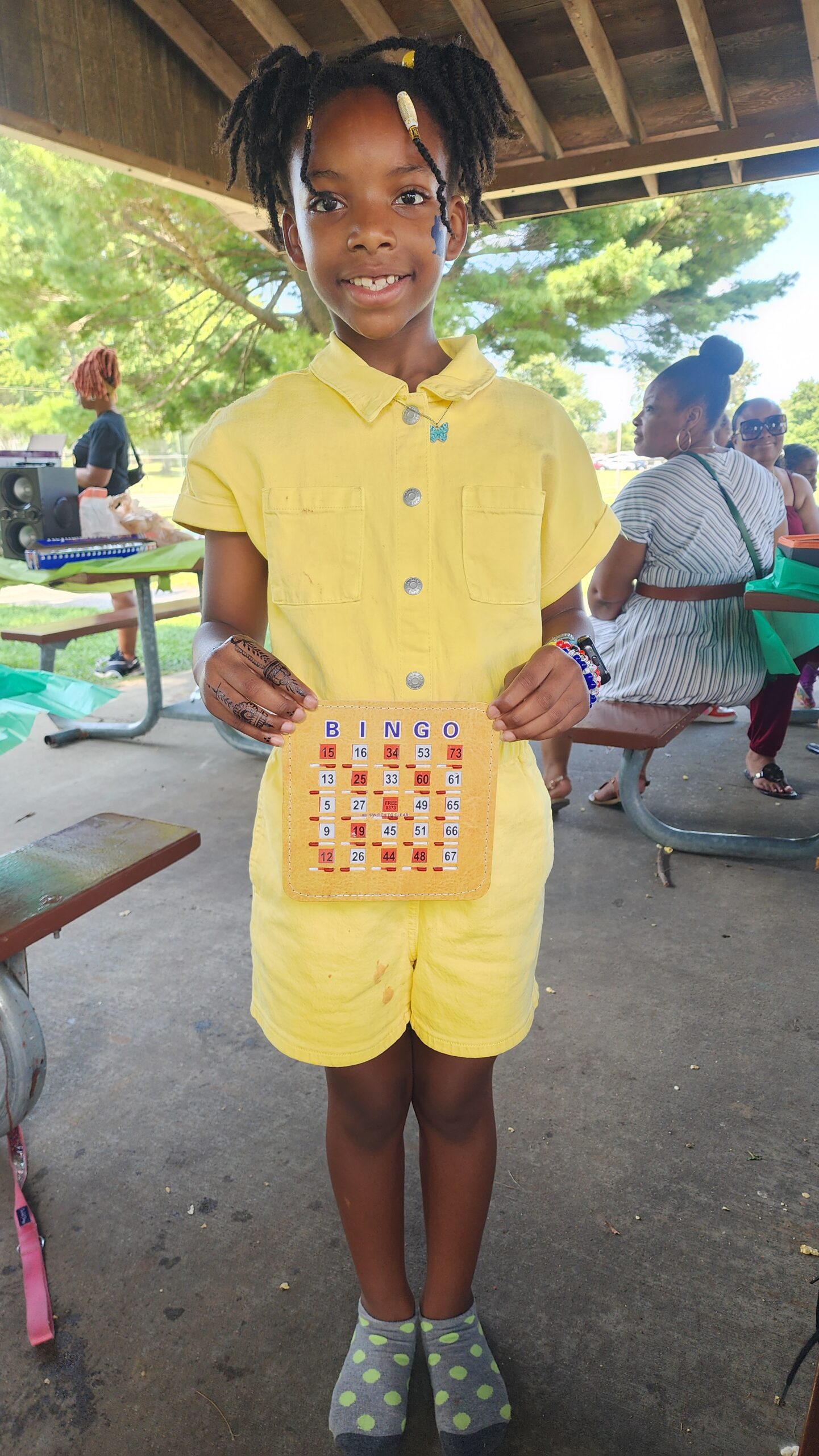 A person in yellow shirt holding a board game.
