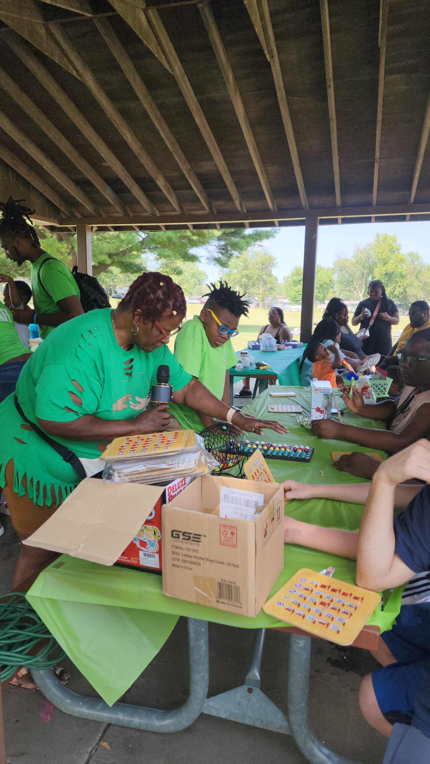 A group of people sitting around tables with boxes.